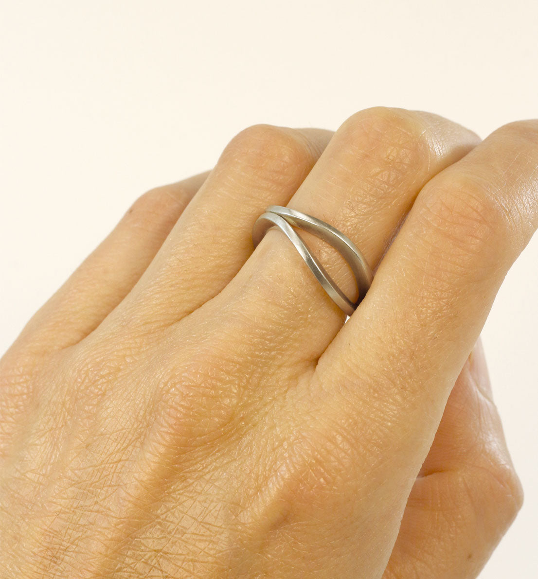 Une bague de créateur en argent massif, un bijou unique et minimaliste composé de deux anneaux courbés. Les bijoux Histoire Botanique sont fabriqués par un artisan français.