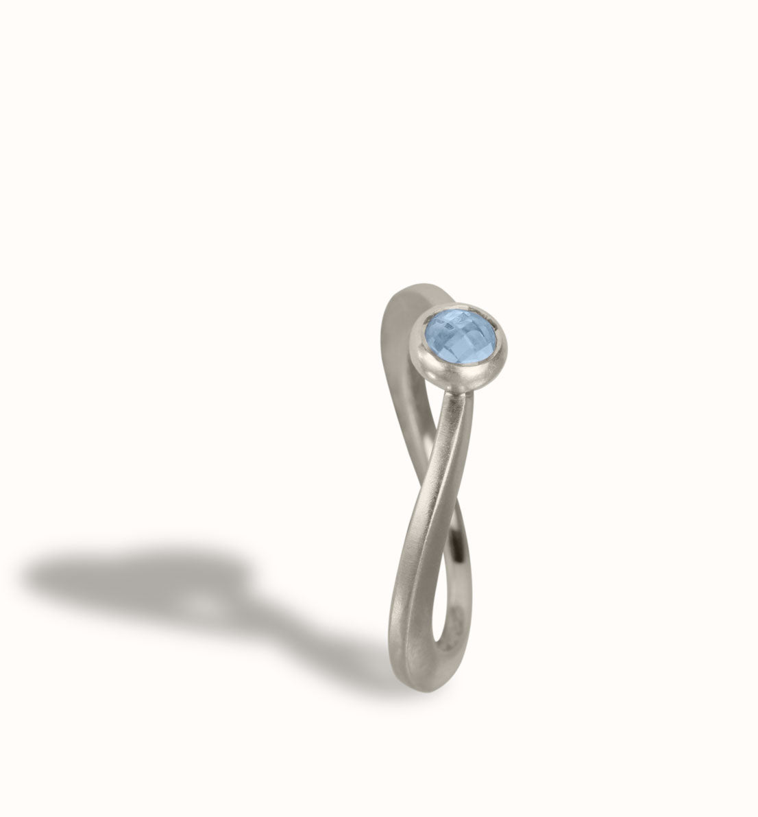 Une bague de créateur en argent massif et pierre à facette bleu, rose ou violette. Un bijou unique inspiré d’une goutte d’eau sur une herbe. Les bijoux Histoire Botanique sont fabriqués par un artisan français.