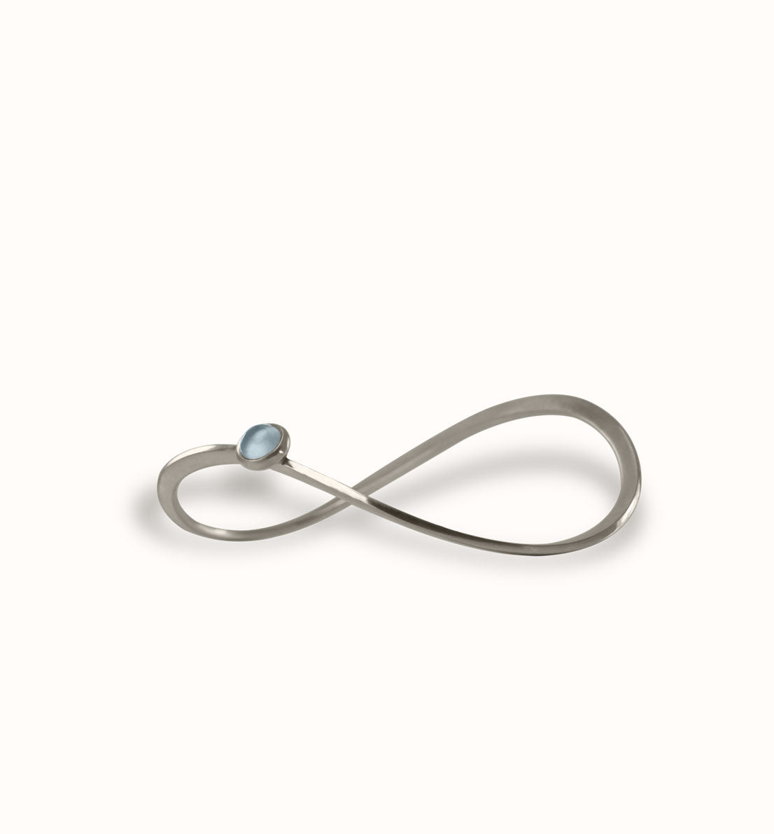 Un bijou unique de créateur. Un bracelet jonc en argent massif serti d’une pierre bleue, rose ou violette inspiré du symbole de l’infini. Les bijoux Histoire Botanique sont fabriqués par un artisan français.