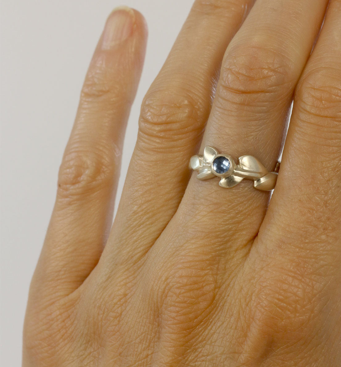 Une bague de créateur en argent massif et pierre bleue, un bijou unique, une frise végétale inspirée des feuilles de globulaire. Les bijoux Histoire Botanique sont fabriqués par un artisan français.