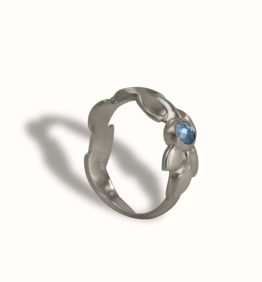 Une bague de créateur en argent massif et pierre bleue, un bijou unique, une frise végétale inspirée des feuilles de globulaire. Les bijoux Histoire Botanique sont fabriqués par un artisan français.