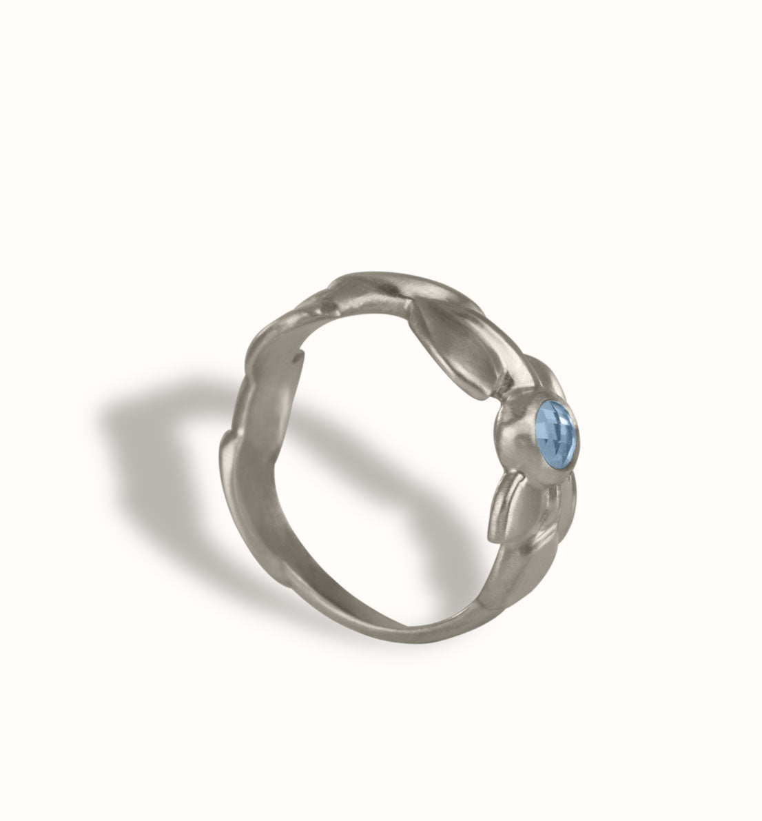 Une bague de créateur en argent massif et pierre bleue, un bijou unique, une frise végétale inspirée des feuilles de globulaire. Les bijoux Histoire Botanique sont fabriqués par un artisan français.