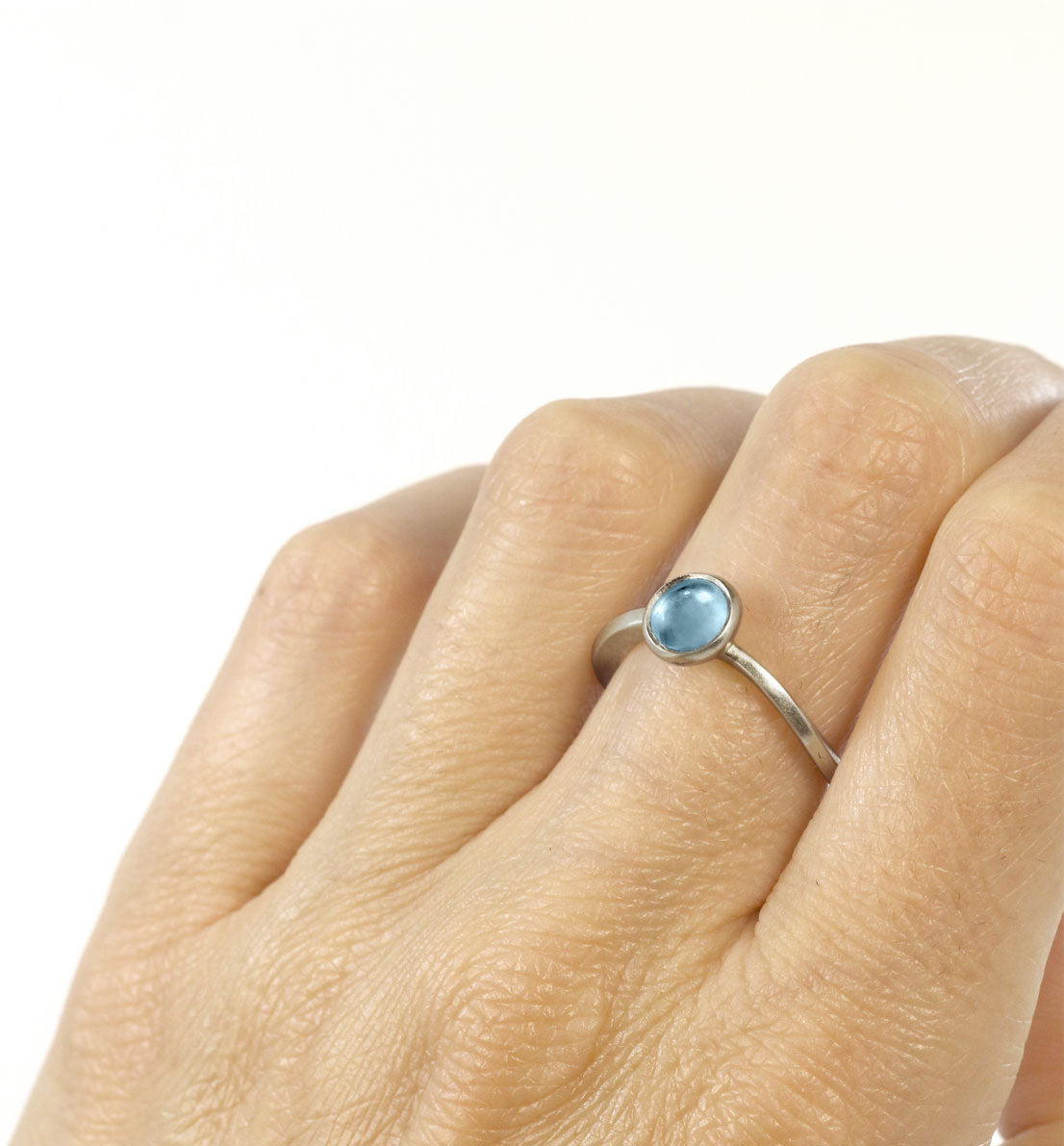 Une bague de créateur en argent massif et pierre bleu, rose ou violette. Un bijou unique inspiré d’une goutte d’eau sur une herbe. Les bijoux Histoire Botanique sont fabriqués par un artisan français.