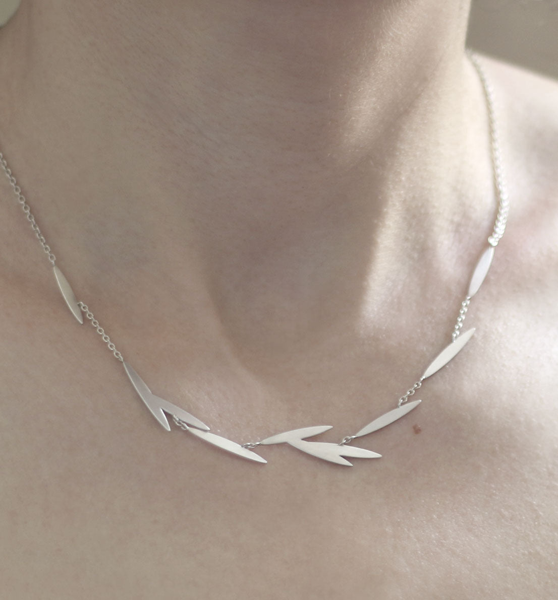 Un bijou unique de créateur. Un collier en argent massif avec des motifs de feuille sur une chaine, inspiré des graines de graminée. Les bijoux Histoire Botanique sont fabriqués par un artisan français.